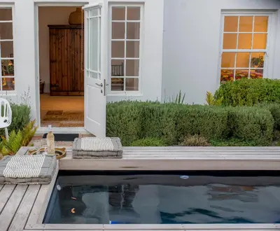 a house with a swimming pool in front of a house at The Vishuis in Hermanus