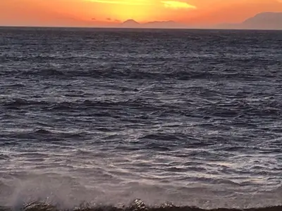 a view of the ocean at sunset at Golf and Garden Guesthouse in Somerset West