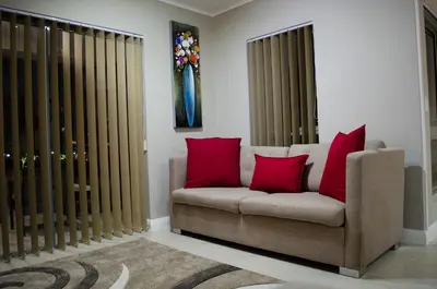 a living room with a couch with red pillows at Mayfair Luxury Apartments in Cape Town