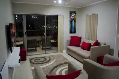 a living room with a couch and red pillows at Mayfair Luxury Apartments in Cape Town