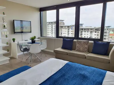 a living room with a couch and a table at Manhattan Luxury Apartments in Cape Town