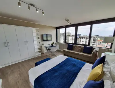 a bedroom with a large bed and a couch at Manhattan Luxury Apartments in Cape Town