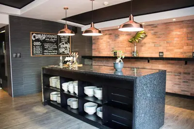 a kitchen with a black counter with plates on shelves at Manhattan Luxury Apartments in Cape Town