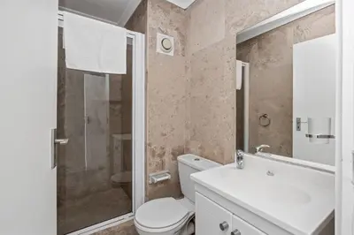 a bathroom with a toilet and a shower and a sink at The Waves 1002 in Bloubergstrand