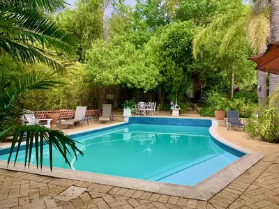 a swimming pool with blue water in a yard at The Little Hideaway Guesthouse in Stellenbosch