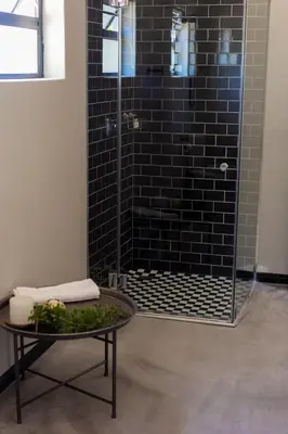 a bathroom with a shower with a table at Rest at Chabivin in Stellenbosch