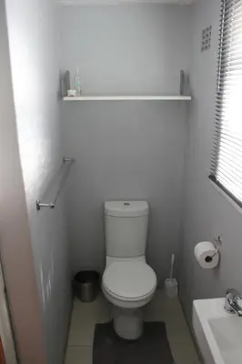 a white bathroom with a toilet and a sink at 25 on Fitzpatrick in Parow
