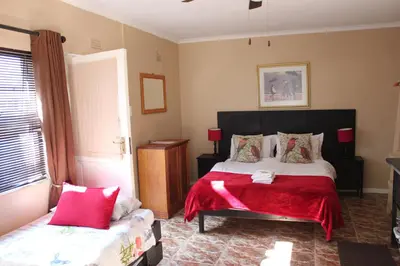 a bedroom with a large bed with a red blanket at 25 on Fitzpatrick in Parow