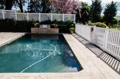 a swimming pool with a basketball hoop in a fence at Lavinia Lifestyle in Stellenbosch