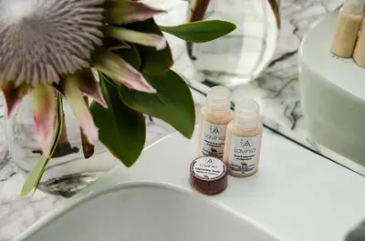 two bottles of medicine sitting on a counter next to a vase at Lavinia Lifestyle in Stellenbosch