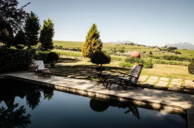 two chairs sitting next to a pool of water at Lavinia Lifestyle in Stellenbosch