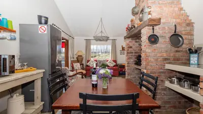 a kitchen with a table and a brick wall at Seven Oaks Vineyard Cottages in Wolseley