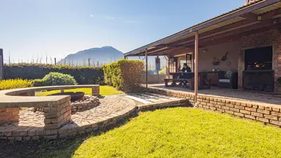 a backyard with a stone bench and a stone wall at Seven Oaks Vineyard Cottages in Wolseley