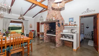 a living room with a brick fireplace at Seven Oaks Vineyard Cottages in Wolseley