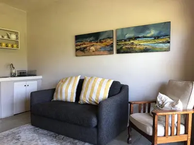 a living room with a couch and a chair at Viettz Suite in Stellenbosch