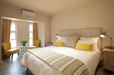 a bedroom with a large white bed with yellow pillows at Viettz Suite in Stellenbosch