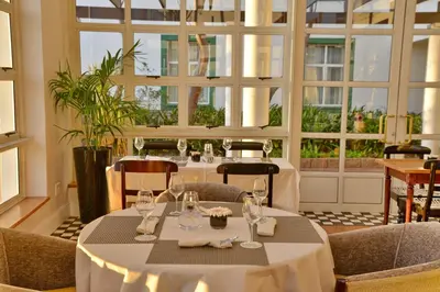 a dining room with tables and chairs and windows at City Lodge Hotel GrandWest in Epping
