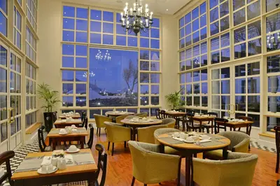 a restaurant with tables and chairs and large windows at City Lodge Hotel GrandWest in Epping