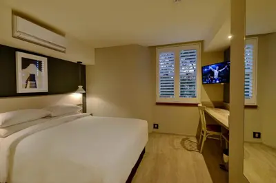 a bedroom with a bed and a desk and a television at Town Lodge Bellville in Bellville