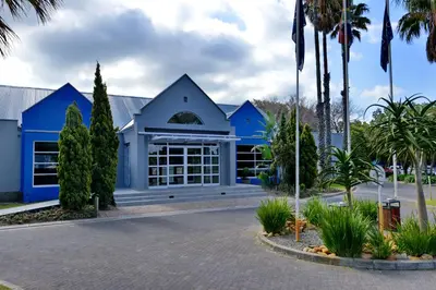 a blue building with palm trees in front of it at Town Lodge Bellville in Bellville