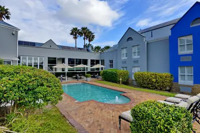 an exterior view of a building with a swimming pool at Town Lodge Bellville in Bellville