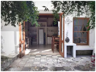 an open door to a patio with a table and chairs at Hartebeeskraal Selfcatering cottage in Paarl