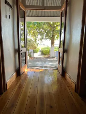an open door into a room with a wooden floor at Hartebeeskraal Selfcatering cottage in Paarl