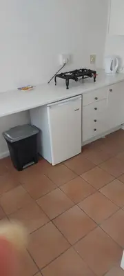 a kitchen with a white counter and a table at Rose Cottage in Hermanus