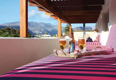 a table with two glasses of wine on a balcony at One Marine Drive Boutique Hotel & Spa by The Living Journey Collection in Hermanus