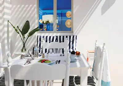 a white table and chairs with a plate of food at One Marine Drive Boutique Hotel & Spa by The Living Journey Collection in Hermanus