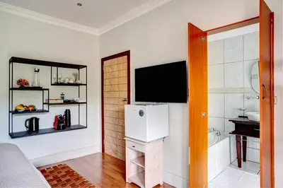 a room with a refrigerator and a television on a wall at Beautiful Abalone in Hermanus