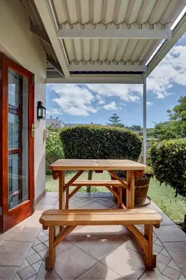 a picnic table on the patio of a house at Beautiful Abalone in Hermanus