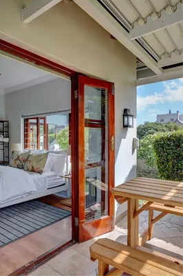 a room with a bed and a table on a patio at Beautiful Abalone in Hermanus