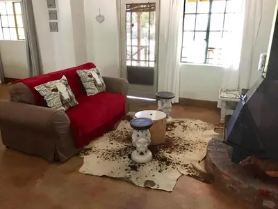a living room with a couch and a tv at Franschhoek Country Cottages in Franschhoek