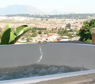 a bath tub with a view of a city at Shirleys Place in Brackenfell