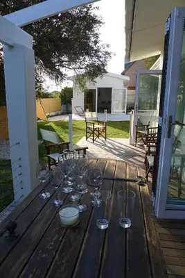 a wooden table with wine glasses on top of it at Pashasha Beach House and Hot Tub in Hermanus