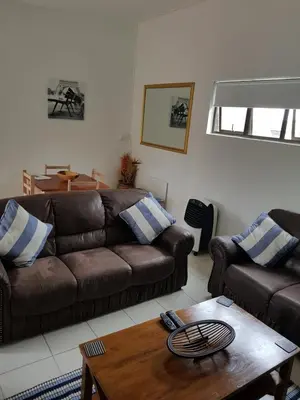 a living room with two brown couches and a coffee table at Stukkie Cottage in Hermanus