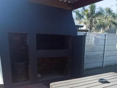 a fireplace in the back of a house at Stukkie Cottage in Hermanus