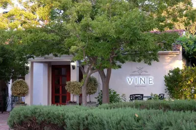 a white building with a sign that reads wine at Vine Guesthouse in Stellenbosch