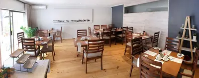 a restaurant with wooden tables and chairs in a room at Vine Guesthouse in Stellenbosch