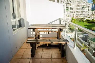 a picnic table on the balcony of a building at Greenways Emerald Bay in Strand