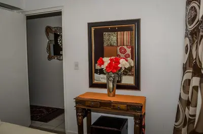 a vase of flowers on a table in a hallway at Greenways Emerald Bay in Strand