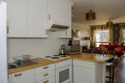 a kitchen with white cabinets and a counter top at Greenways Emerald Bay in Strand