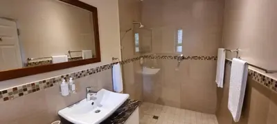 a bathroom with a sink and a mirror at SomerZicht Guest House in Somerset West