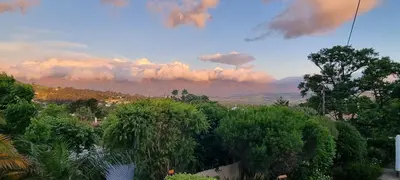 a view of trees and mountains with a cloudy sky at SomerZicht Guest House in Somerset West
