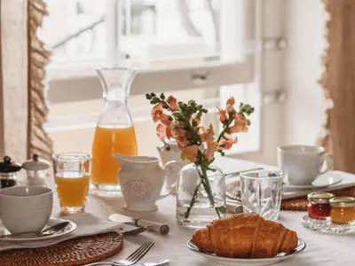 a table with a plate of bread and orange juice at Le Petit Paris in Franschhoek