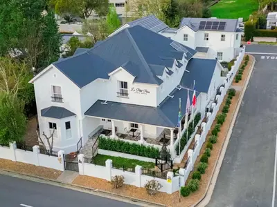 an aerial view of a white house with a blue roof at Le Petit Paris in Franschhoek