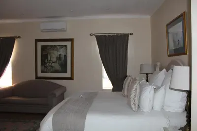 a hotel room with a large bed and a couch at Cinnamon House Bed & Breakfast in Cape Town