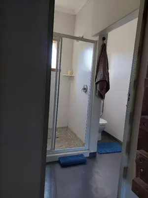 a bathroom with a shower with a glass door at Kimi's Cottage in Simondium