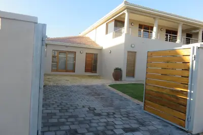 a house with a wooden gate in front of it at Waves Echo in Bloubergstrand